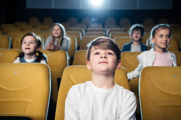 Милые внимательные дети вместе смотрят кино в кино — стоковое фото