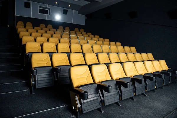 Sala de cine oscuro con cómodos asientos vacíos con portavasos - foto de stock