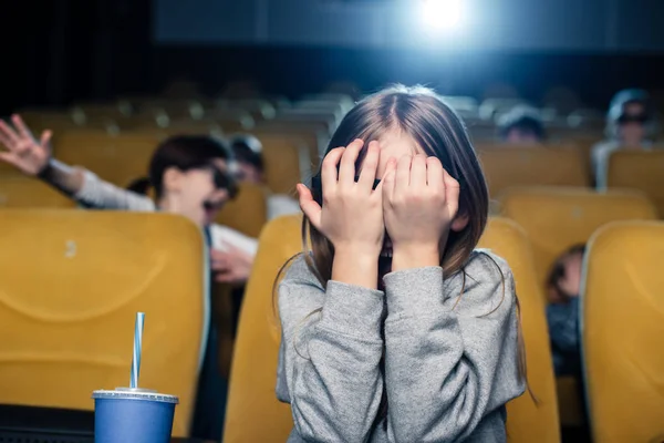 Niño asustado agarrado de la mano mientras ve películas en el cine - foto de stock