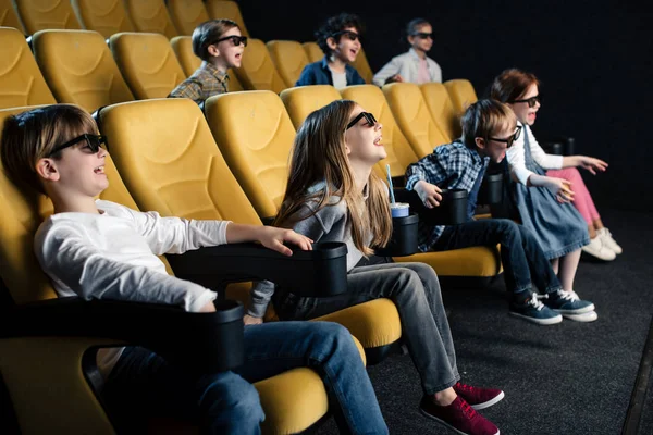 Amigos multiculturais alegres em óculos 3d assistindo filme no cinema — Fotografia de Stock