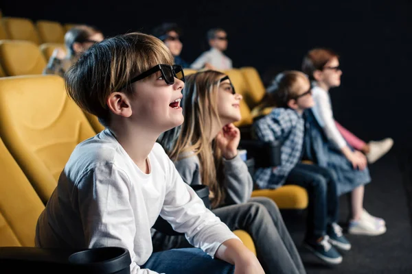 Enfoque selectivo de lindo chico en gafas 3d viendo la película en el cine junto con amigos - foto de stock