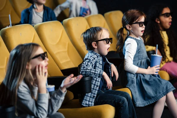 Amigos multiculturales emocionados en gafas 3d viendo películas en el cine - foto de stock