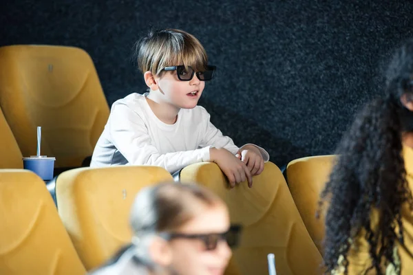 Enfoque selectivo de chico lindo en gafas 3d pasar tiempo en el cine junto con amigos multiculturales - foto de stock