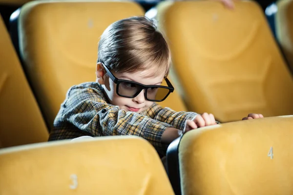 Lindo sonriente chico en 3d gafas sentado en cómodo cine asiento - foto de stock