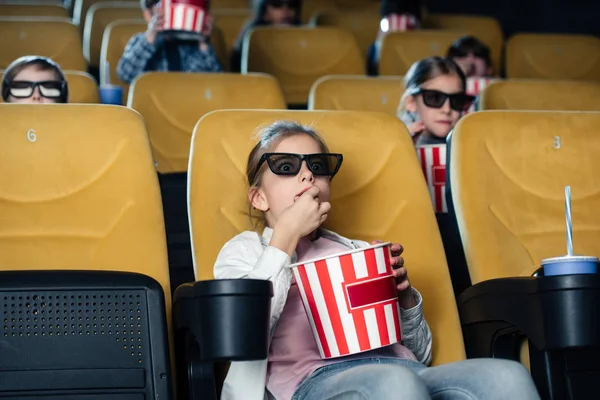 Friends watching movie and eating pop corn in cinema together — Stock Photo