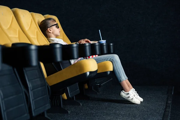 Enfoque selectivo del niño sentado en el asiento de cine con taza de papel - foto de stock