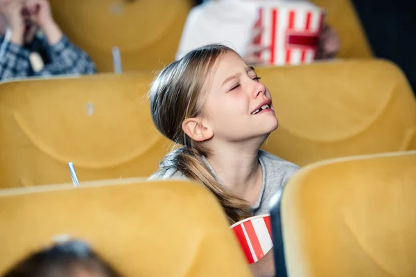Lindo niño molesto llorando mientras mira la película en el cine - foto de stock