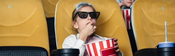 Panoramic shot of cute child in 3d glasses eating popcorn in cinema — Stock Photo