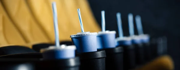 Foyer sélectif de sièges de cinéma orange avec des tasses en papier bleu dans les porte-gobelets — Photo de stock