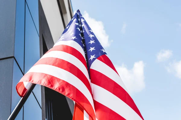 Vista de ángulo bajo de la bandera nacional de América con estrellas y rayas cerca de la construcción - foto de stock