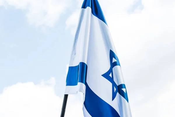 Baixo ângulo de visão da bandeira nacional de israel com estrela azul de david contra o céu com nuvens — Fotografia de Stock