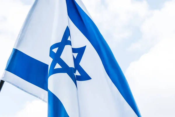Bandera nacional de Israel con estrella de David contra el cielo con nubes - foto de stock