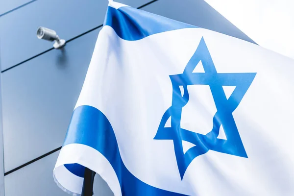 Baixo ângulo de visão da bandeira nacional de israel com estrela de david perto do edifício — Fotografia de Stock