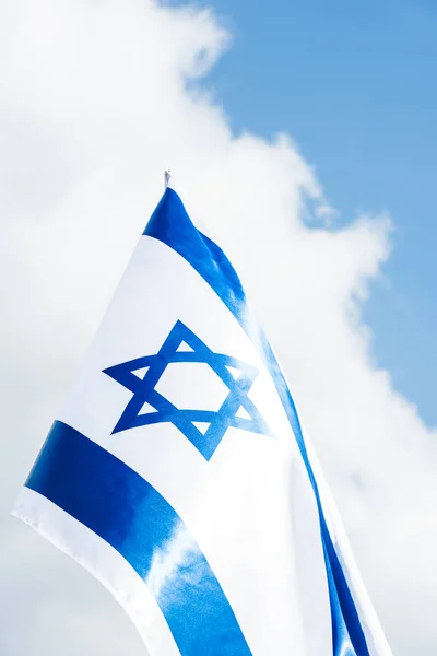 Visão de baixo ângulo da bandeira nacional de israel com estrela azul de david contra o céu com nuvens — Fotografia de Stock