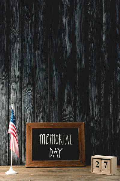 Chalkboard with memorial day lettering near american flag and cubes with date — Stock Photo
