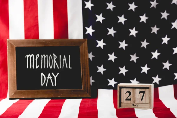 Inscripción del día memorial en pizarra cerca de cubos de madera con fecha y bandera de América - foto de stock