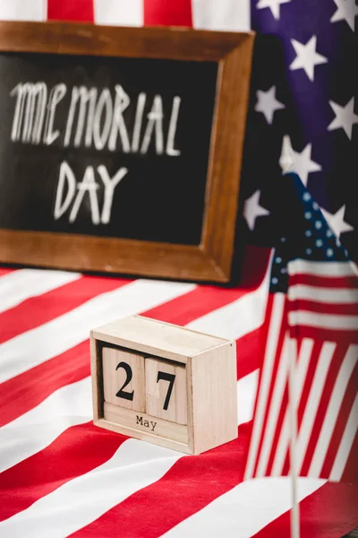 Würfel mit Datum in der Nähe der amerikanischen Flagge mit Sternen und Streifen und Gedenktag Schriftzug auf Kreide — Stockfoto