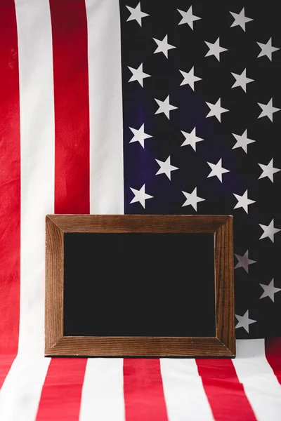 Tableau noir vide près du drapeau national américain — Photo de stock