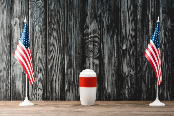 Funeral urn with ashes near american flags — Stock Photo