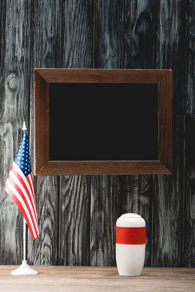 Leere Tafel neben Beerdigungsurne mit Asche und amerikanischer Flagge — Stockfoto