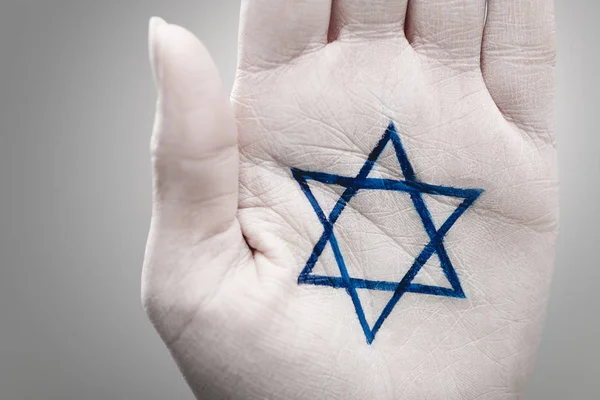 Close up of female hand with star of david on grey — Stock Photo