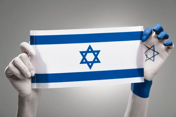 Обрізаний вигляд жіночих рук тримає Національний прапор Ізраїлю на сірому — стокове фото