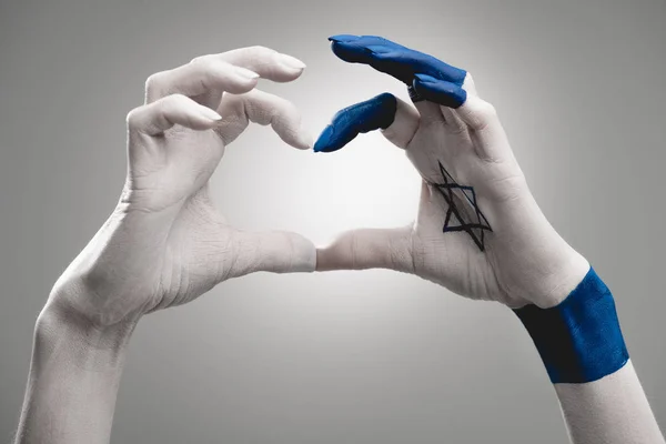 Обрезанный вид женских рук с голубой звездой Дэвида, показывающей сердце на сером — стоковое фото