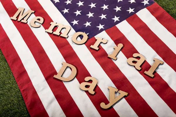Memorial day lettering on american flag with stars and stripes on green grass — Stock Photo