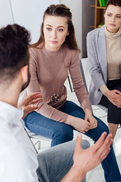 Women and man sitting and having discussion during group therapy session — Stock Photo