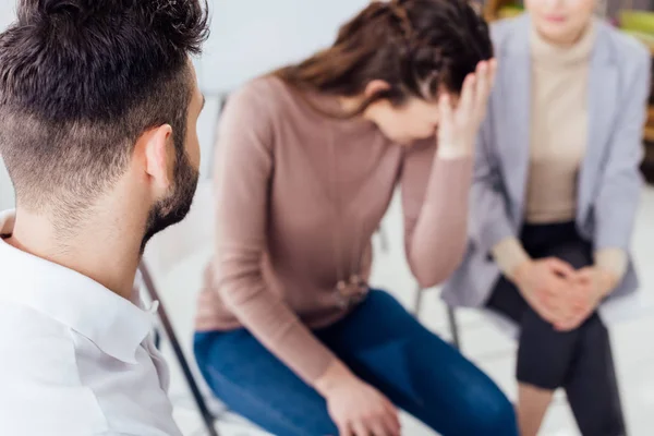 Woman covering face and crying during group therapy session — Stock Photo