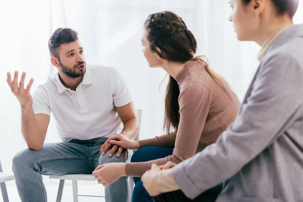 Donne e uomini seduti e in discussione durante la sessione di terapia di gruppo — Foto stock