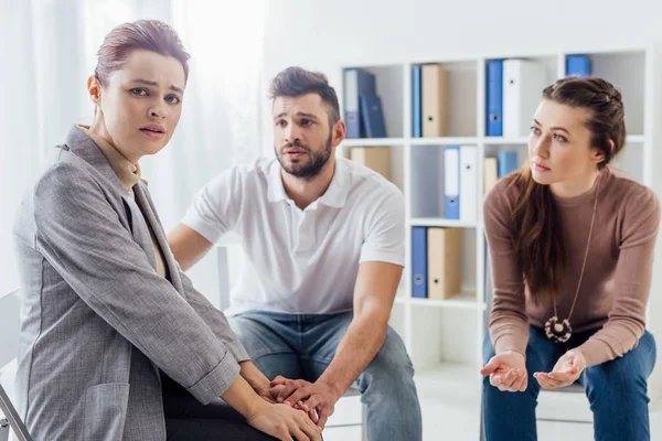 Upset woman looking at camera during group therapy session — Stock Photo