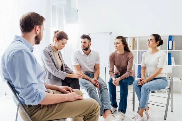 Personas con ropa casual sentadas en sillas durante la sesión de grupo de apoyo - foto de stock