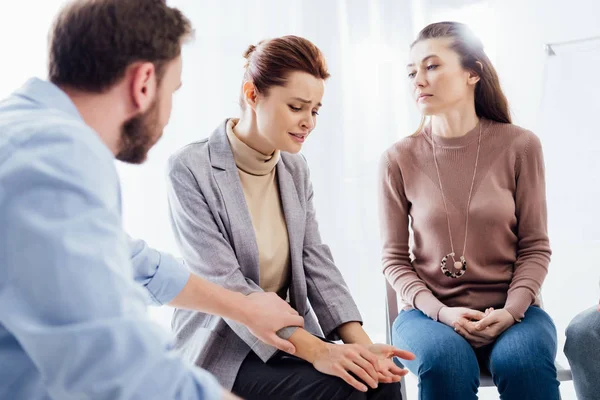 Mann tröstet depressive Frau während Gruppentherapie — Stockfoto