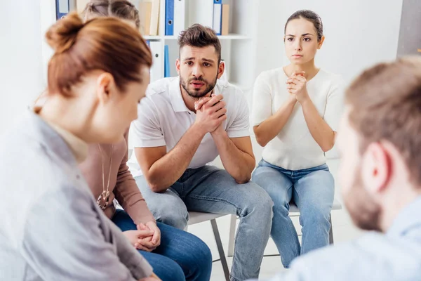 Personas sentadas en sillas y teniendo una reunión de terapia de grupo - foto de stock