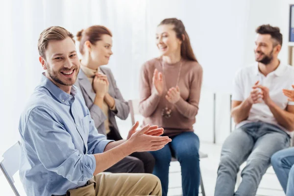 Group of people smiling and applauding during support group session — Stock Photo