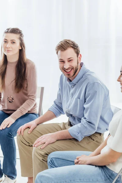 Schöner Mann lächelt während Gruppentherapie-Sitzung — Stockfoto
