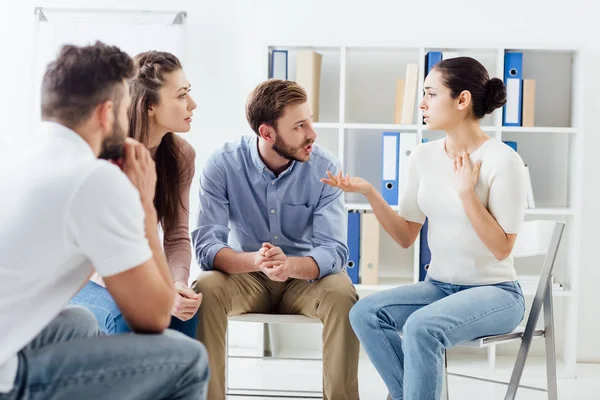Люди, сидящие и обсуждающие во время групповой терапии — стоковое фото