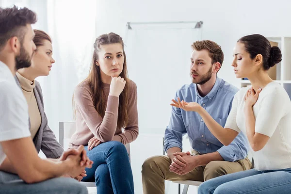 People sitting on chairs and having discussion during support group meeting — Stock Photo