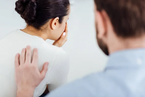 Visão traseira do homem consolador mulher durante a reunião de terapia — Fotografia de Stock