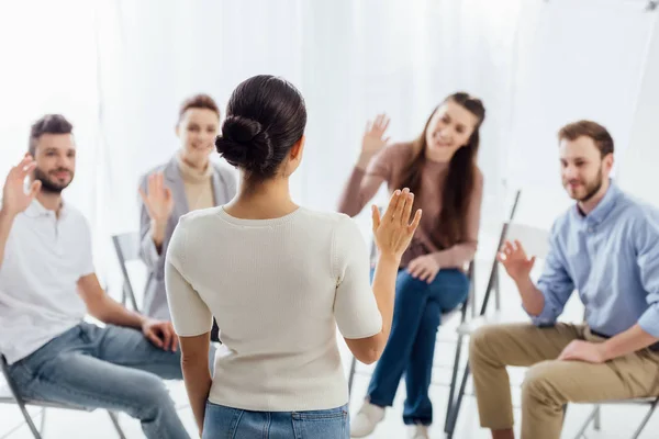 Люди сидять і піднімають руки під час групової терапії — стокове фото