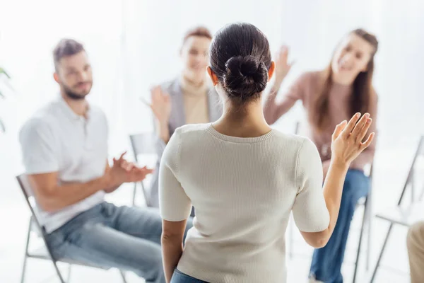 Personas sentadas y levantando las manos durante la sesión de terapia de grupo - foto de stock