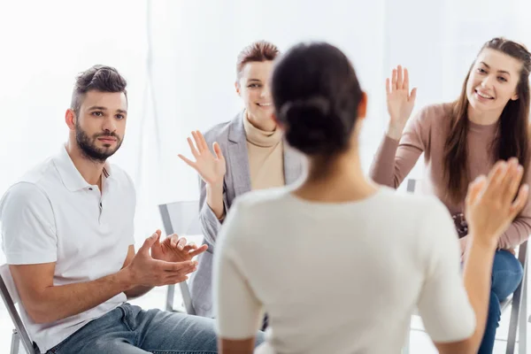 Selective focus of people sitting and raising hands during group therapy session — Stock Photo