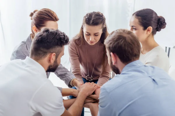 Persone sedute impilare le mani durante la sessione di terapia di gruppo — Foto stock