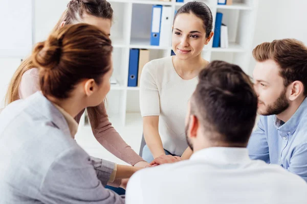 People sitting stacking hands during group therapy session — Stock Photo