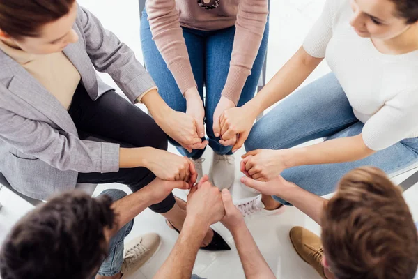 Top view of people holding hands during group therapy session — Stock Photo