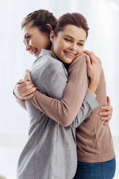 Schöne glückliche Frauen, die sich während des Therapietreffens umarmen — Stockfoto