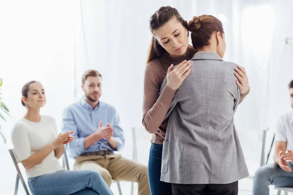 Foyer sélectif des femmes étreignant pendant la séance de thérapie de groupe — Photo de stock