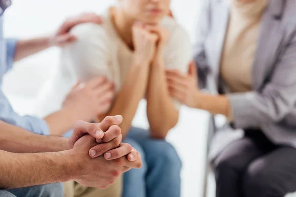 Vista recortada del hombre con las manos dobladas durante la sesión de terapia de grupo - foto de stock