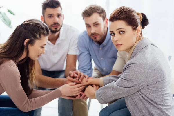 Group of people sitting and stacking hands during therapy session — Stock Photo